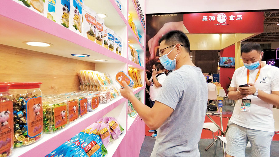 ●一名消費者在大灣區食品博覽會上仔細挑選。 香港文匯報記者盧靜怡  攝