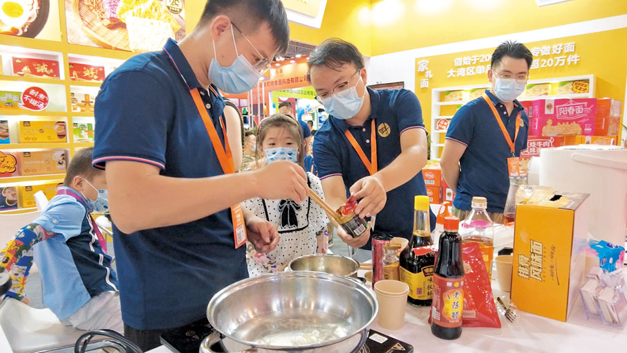 ●大灣區食品博覽會現場氣氛熱鬧，不少展位負責人為觀眾現場烹飪食物。 香港文匯報記者盧靜怡  攝